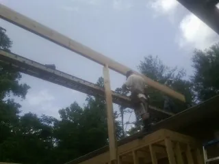 Carpenter setting a ridge beam over a new addition frame — Ice Dam Removal by Roofing Brothers in Roanoke Rapids