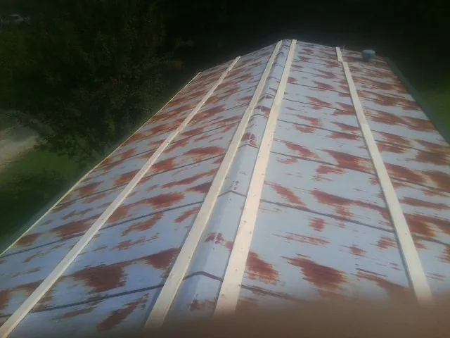 Rusted metal roof panels with new wood purlins before replacement — Storm Damage Roof Repair in Roanoke Rapids by Roofing Brothers