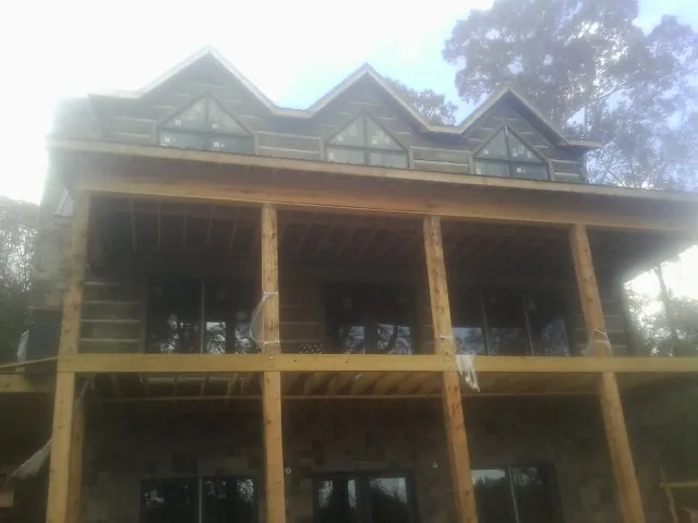 Dormers and porch framing on a large log home under construction — Roof Coating work by our crew in Roanoke Rapids