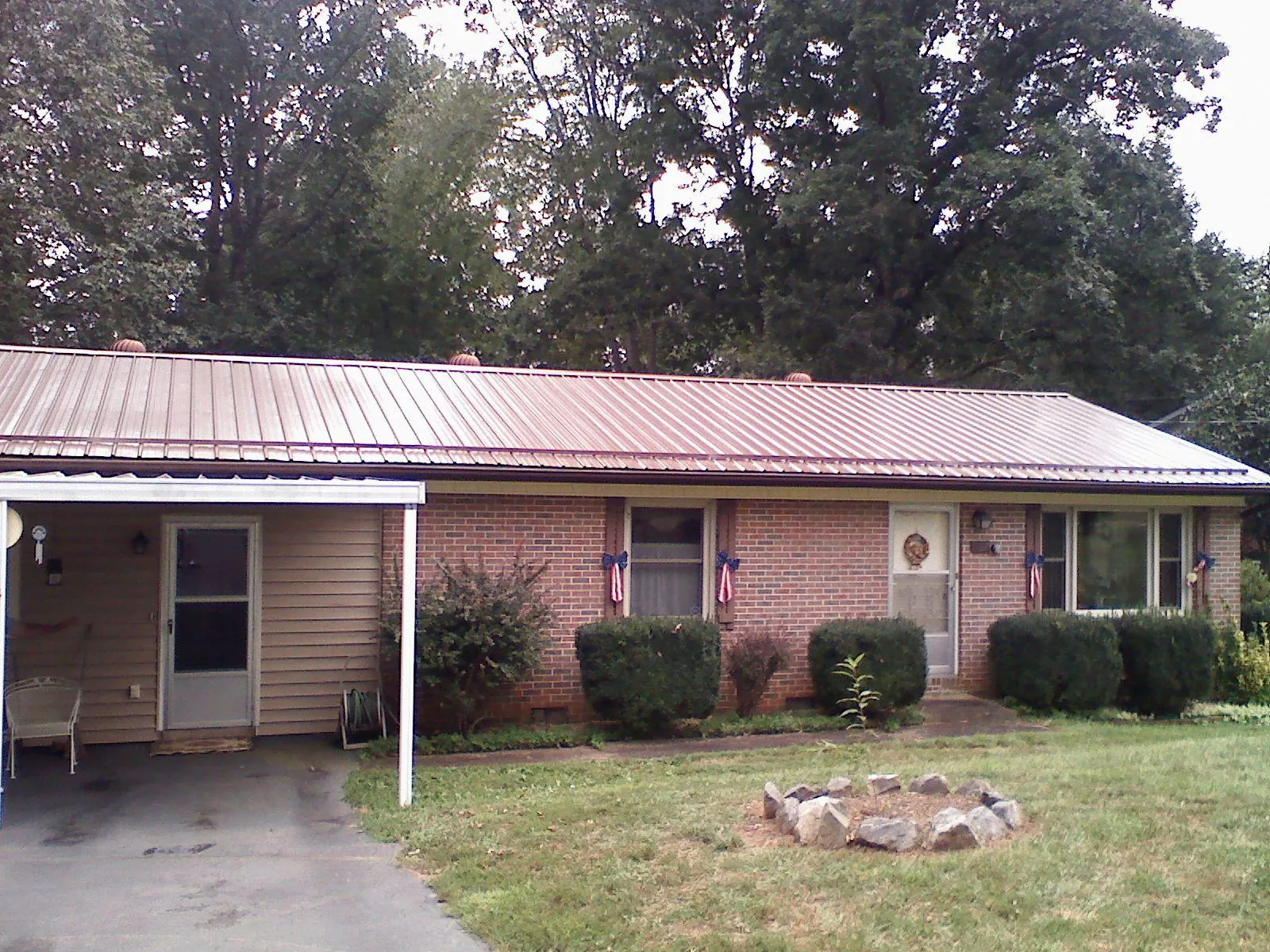 Bronze metal roof and carport on a brick ranch home — Roof Repair work by our crew in Roanoke Rapids