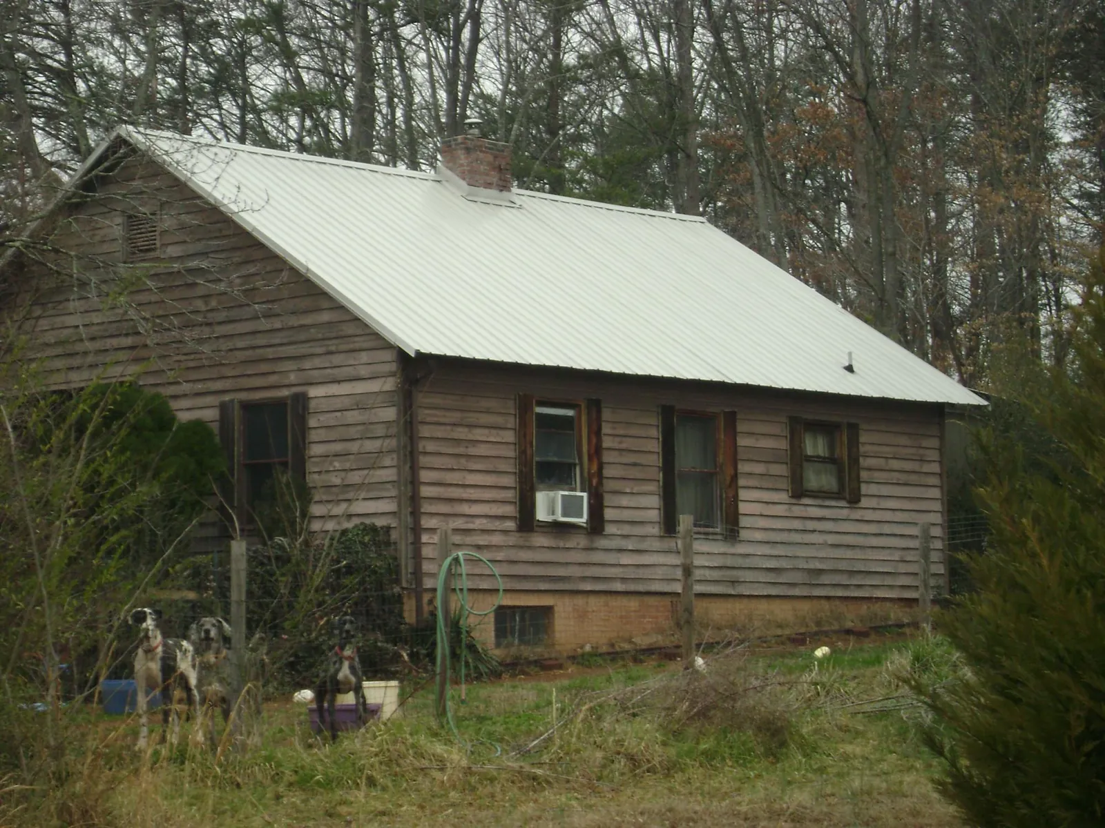 White metal roof on an old wood sided farmhouse, from a Metal Roof Installation job in Roanoke Rapids